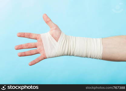 Fractures and dislocations concept. Male hand in white bandage. Helpful medication for painful palm arm of young man.. Male hand in bandage.