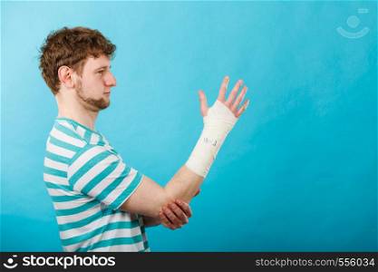 Fractures and dislocations concept. Man with hand in bandage. Helpful medication for painful palm arm of young guy.. Man with hand in bandage.