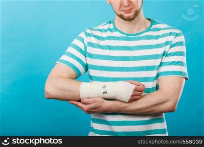 Fractures and dislocations concept. Man with hand in bandage. Helpful medication for painful palm arm of young guy.. Man with hand in bandage.