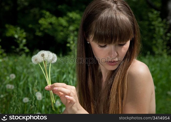 fragile girl with dandelions. blowballs