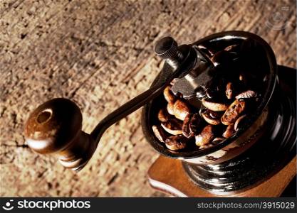 Fragment grinder with roasted coffee beans on a wooden background