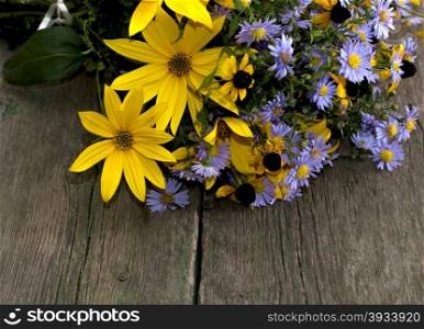 fragment of a bouquet of wild flowers on a wooden table, a subject autumn