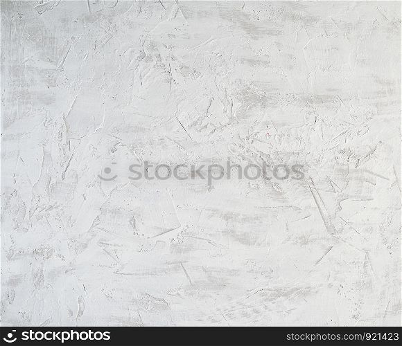 fragment of a cement background from white and gray paint with cracks, stains of paint, vintage background