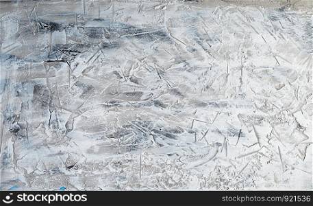 fragment of a cement background from white and gray paint with cracks, stains of paint, vintage background