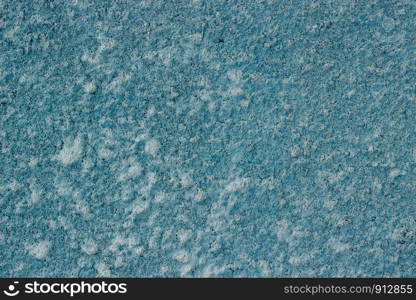 Fragment of a concrete wall painted with blue paint as a background or texture. Seamless texture.