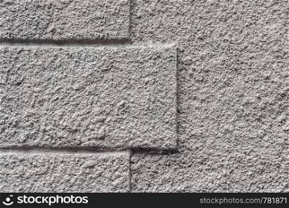 Fragment of a gray concrete wall with protrusions in the shape of a rectangle. Cladding material. Background or texture. For design or text.