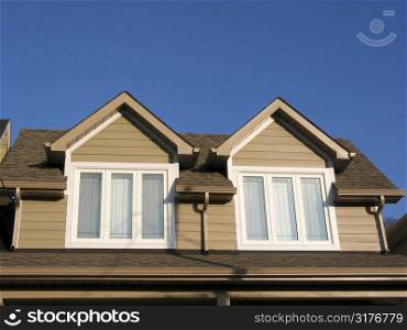 Fragment of a new custom built house on the background of bright blue sky