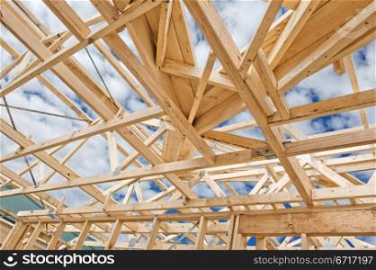 Fragment of a new residential construction home framing against a blue sky