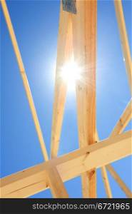 Fragment of a new residential construction home framing against a blue sky