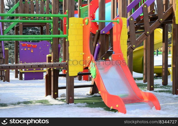 Fragment of a playground made of plastic and wood, painted in different colors