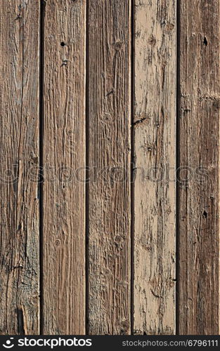 Fragment of aged wooden boards background with peeling brown paint