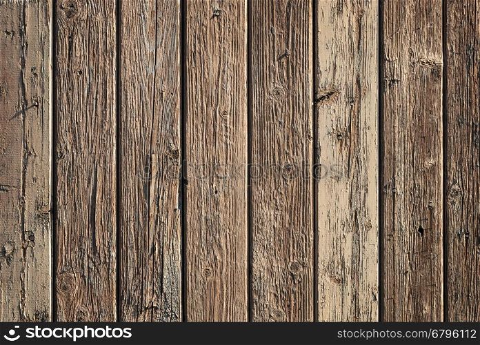 Fragment of aged wooden boards background with peeling brown paint