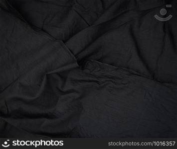 fragment of black cotton fabric with waves, full frame, close up