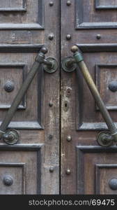 fragment of brown old entrance doors with large copper handles