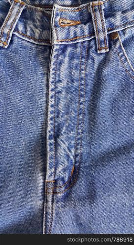 Fragment of classic blue fashioned jeans, close-up texture