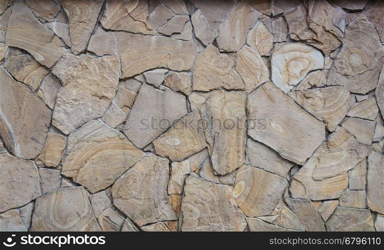 Fragment of decorative brown facing of stone wall