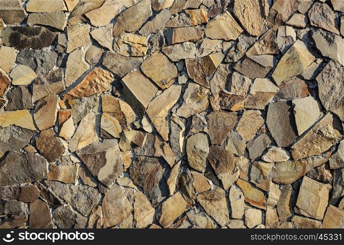 Fragment of decorative brown facing of stone wall surface