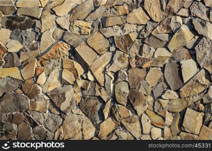 Fragment of decorative brown facing of stone wall surface