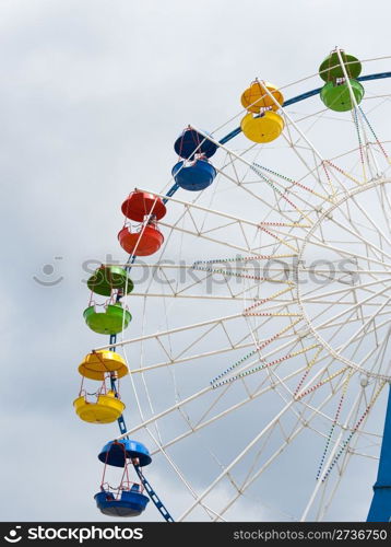 fragment of Ferris wheel against cloudy sky