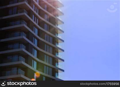 Fragment of modern multi-storey residential building against blue sky. Close-up. Background for ad or banner. Copy space. modern housing. sale of apartments. Fragment of modern multi-storey residential building against blue sky. Close-up. Background for ad or banner. Copy space. modern housing. sale of apartments.