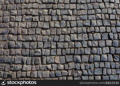 Fragment of old gray cobblestone pavement texture