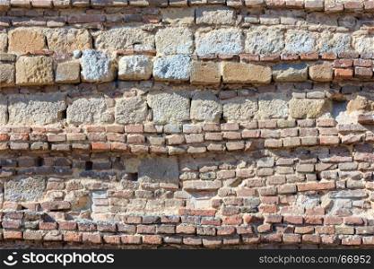 Fragment of old stone wall closeup (architectural background pattern).