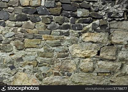 Fragment of old stone wall with formless boulders