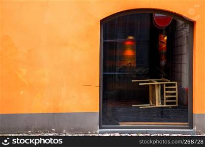 Fragment of orange wall with shop window in Old Riga, Latvia.