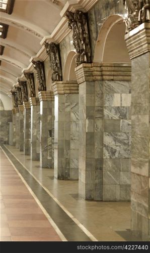 Fragment of the interior with columns lined with gray granite and metal decor. Interior with columns