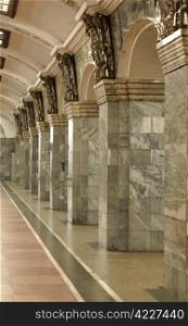 Fragment of the interior with columns lined with gray granite and metal decor. Interior with columns