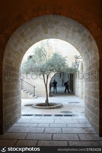 Fragments of the Old City of Jerusalem, a street with an arch and courtyard with a tree.