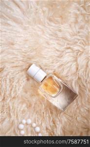 fragrance bottle at sheepskin fur. glamour concept. flat lay