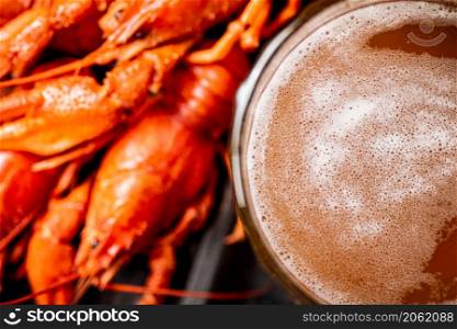 Fragrant boiled crayfish on the table. On a wooden background. High quality photo. Fragrant boiled crayfish on the table.
