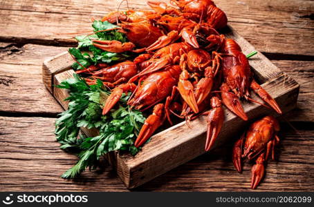 Fragrant boiled crayfish on the table. On a wooden background. High quality photo. Fragrant boiled crayfish on the table.