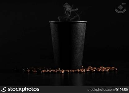 fragrant coffee on the table A black glass with hot coffee on a dark background. scattered coffee beans.. A black glass with hot coffee on a dark background. scattered coffee beans. fragrant coffee on the table