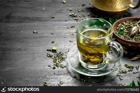 fragrant green tea in a mug. On the black chalkboard. fragrant green tea in a mug.