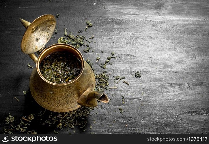 Fragrant green tea in an old teapot. On the black chalkboard. Fragrant green tea in an old teapot.
