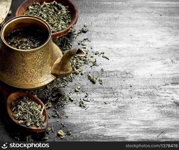 Fragrant green tea in an old teapot. On the black chalkboard. Fragrant green tea in an old teapot.