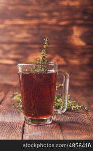 Fragrant herbal tea with bunches thyme in a glass mug. The thyme tea