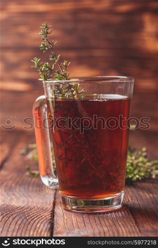 Fragrant herbal tea with bunches thyme in a glass mug. The thyme tea