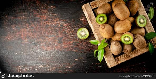 Fragrant kiwi with leaves on tray. On a rustic dark background. High quality photo. Fragrant kiwi with leaves on tray.