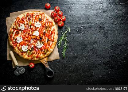 Fragrant pizza with tomatoes and rosemary. On black rustic background. Fragrant pizza with tomatoes and rosemary.