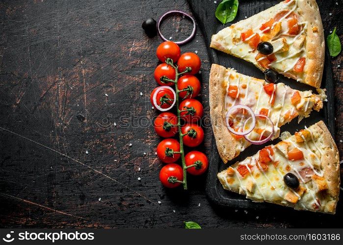 Fragrant slices of pizza on a cutting Board. On dark rustic background. Fragrant slices of pizza on a cutting Board.