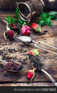 fragrant tea brew. Stylish spoons with variety of tea on vintage wooden board.