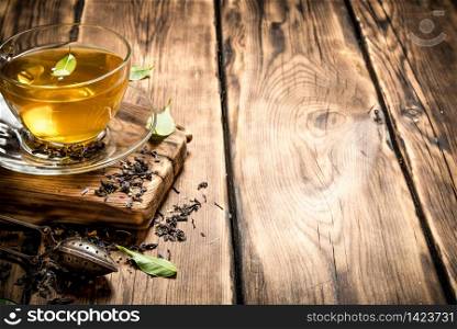 fragrant tea with infuser spoon. On wooden background.. fragrant tea with infuser spoon.