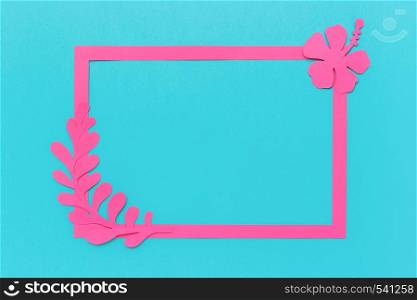 Frame and trendy pink tropical leaves, flower of paper on blue background Copy space Template for your design or lettering, text Creative Flat lay Top view Greeting card.. Frame and trendy pink tropical leaves, flower of paper on blue background Copy space Template for your design or lettering, text Creative Flat lay Top view Greeting card