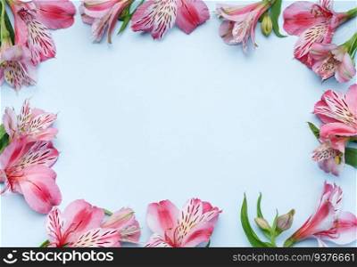 Frame for the text of congratulations with  flowers of Alstroemeria on a blue background. Greeting card with natural colors. Background for text with alstromeria. Flat lay, top view.
