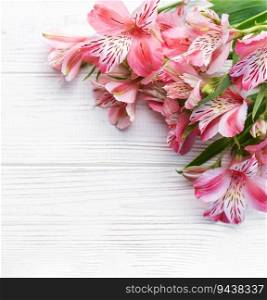 Frame for the text of congratulations with  flowers of Alstroemeria on a wooden background. Greeting card with natural colors. Background for text with alstromeria. Flat lay, top view.