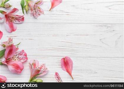 Frame for the text of congratulations with  flowers of Alstroemeria on a wooden background. Greeting card with natural colors. Background for text with alstromeria. Flat lay, top view.