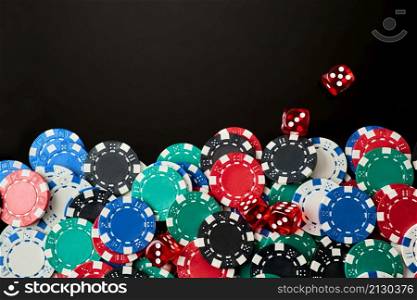 Frame made of Casino chips and dices on dark reflective background with copy space.. Frame made of Casino chips and dices on dark reflective background with copy space